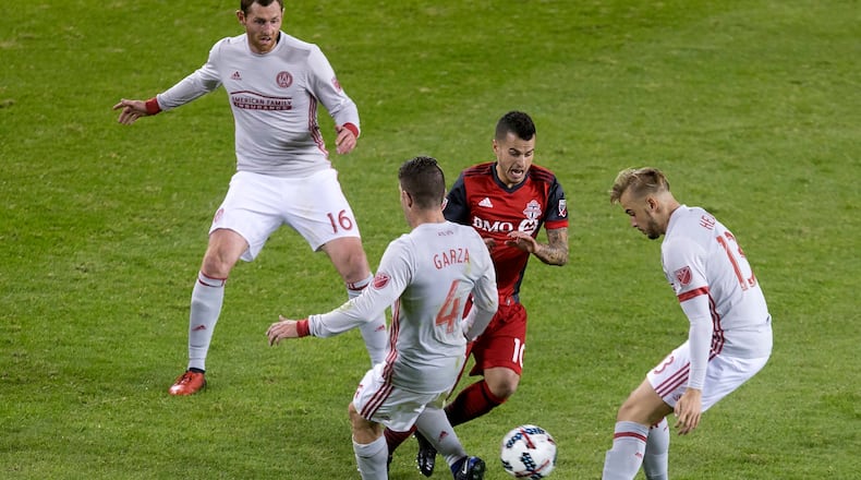 Toronto FC forward Sebastian Giovinco (10) tries to take the ball between Atlanta United’s Harrison Heath (13) and Greg Garza (4) as Chris McCann gives chase during the second half of an MLS soccer match Saturday, April 8, 2017, in Toronto. (Chris Young/The Canadian Press via AP)