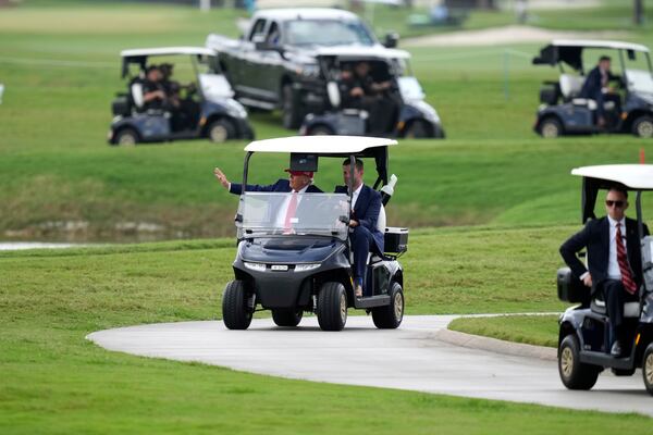 President Donald Trump, driven by his son Eric Trump, arrives at Trump National Doral during the LIV Golf Miami tournament, Thursday, April 3, 2025, in Miami. (AP Photo/Alex Brandon)