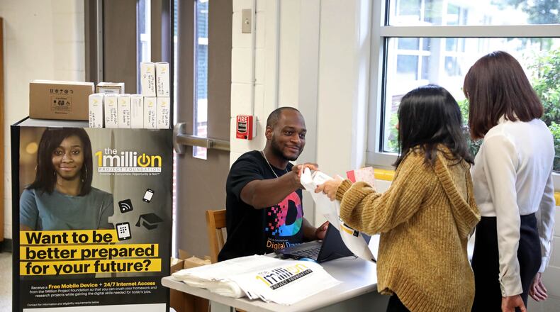 DeKalb County Schools information technology employee Cedrick Greer distributes hot spots to high school students as a part of the Sprint One Million Project at Cross Keys High School on Sept. 13, 2018, in Atlanta. (JASON GETZ/SPECIAL TO THE AJC)