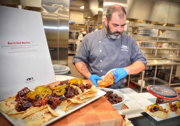  Chef Alan Knight prepares Burnt End Nachos that feature brisket, tortilla chips, white cheese sauce, Budweiser BBQ sauce and jalapenos. This dish is available at the Smoke N Pour concession stands in Sections 117 and 316. (Chris Hunt/Special)