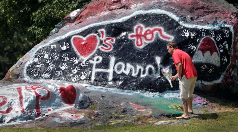 Jason Flanagan, who said he was a neighbor of Hannah Truelove, stopped by the rock to leave a bouquet of flowers in this AJC file photo. Gainesville high students painted a memorial to Hannah Truelove on "the Rock" near campus.