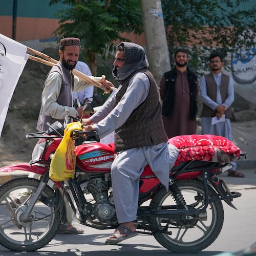 A man offers Taliban flags for sale ahead of celebrations marking the fifth anniversary of the U.S. withdrawal from Afghanistan and the start of Taliban rule, in Kabul, Afghanistan, Thursday, Aug. 13, 2026. (AP Photo/Siddiqullah Alizai)