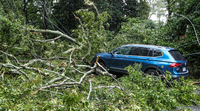 September 17, 2020 Atlanta: Atlanta Fire Rescue kept an apparatus on the scene where a tree brought wires down across Peachtree Battle at Havenridge Drive in Atlanta in Atlanta. Officials at the scene did not disclose the condition of the driver of the vehicle. Remnants of Hurricane Sally, that downgraded to a tropical depression, moved through North Georgia on Thursday, Sept. 17, 2020. Heavy rain and flooding brought trees down and made a mess of the Thursday morning commute and knocked out power to thousands. By mid-day, Fulton, DeKalb and Gwinnett counties received between 2 and 4 inches of rain, and the Southside, between 1 and 3 inches. Those areas could see as much as another 4 inches of rain before the end of the day, according to rain forecast.  (John Spink / John.Spink@ajc.com)