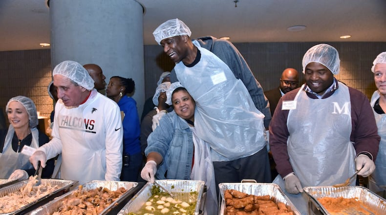 Volunteers including former Atlanta Hawks player Dikembe Mutombo (center) worked the food line, filling trays with individual meals during the annual Hosea Feed the Hungry and Homeless Thanksgiving dinner at the Georgia World Congress Center on Nov. 24, 2016. The nonprofit, now known as Hosea Helps, is raising money to move to a new location because it needs to leave its current site. HYOSUB SHIN / HSHIN@AJC.COM