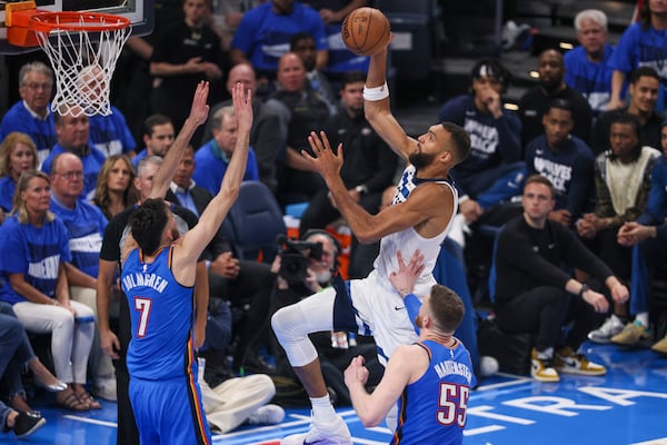 Minnesota Timberwolves center Rudy Gobert, top, goes up for a basket against Oklahoma City Thunder forward Chet Holmgren (7) and center Isaiah Hartenstein (55) during the first half of Game 2 of an NBA basketball Western Conference Finals playoff series Thursday, May 22, 2025, in Oklahoma City. (AP Photo/Nate Billings)