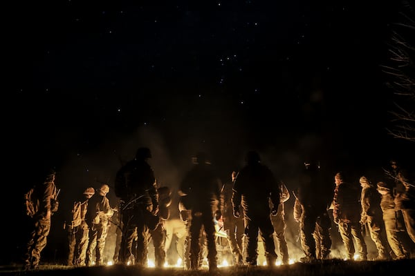 In this photo taken on March 21, 2025 and provided by Ukraine's 24th Mechanized Brigade press service on March 24, 2025, servicemen attend a dedication ceremony for soldiers near the frontline in the Donetsk region, Ukraine. (Oleg Petrasiuk/Ukraine's 24th Mechanized Brigade via AP)
