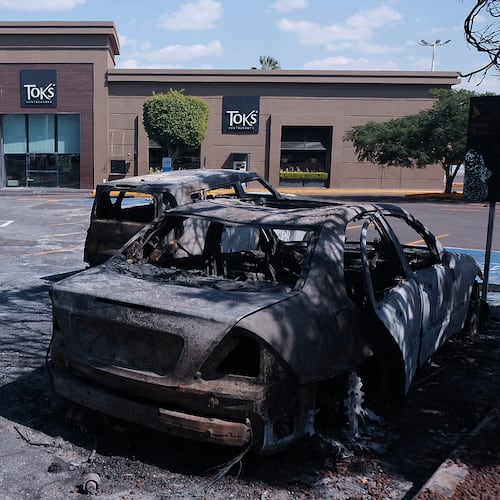 Charred vehicles sit in a parking lot sit outside a shopping mall in Guadalajara, Jalisco state, Mexico, Sunday, Feb. 22, 2026, as authorities reported that the Mexican Army killed Jalisco New Generation Cartel leader Nemesio Oseguera, known as "El Mencho." (AP Photo/Alejandra Leyva)