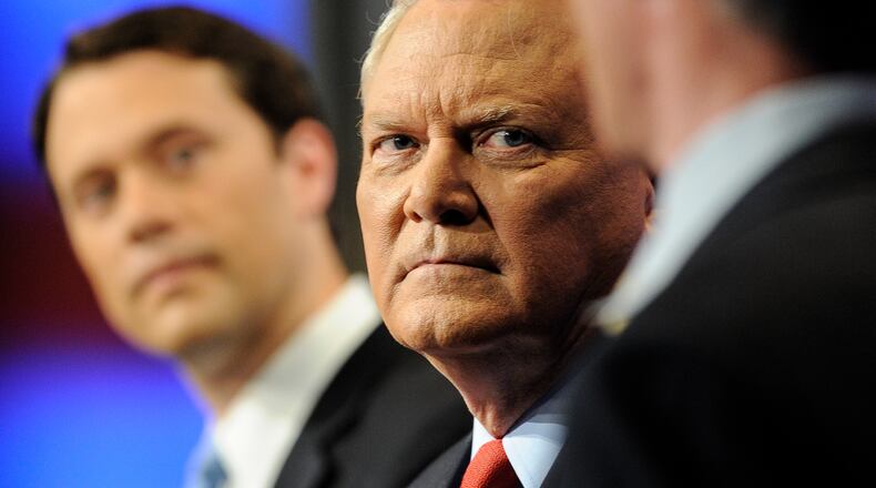 Republican candidate and incumbent Governor Nathan Deal, center, listens to Libertarian candidate and and former CEO of a nano technology company Andrew Hunt, right, as does Democratic candidate and State Senator Jason Carter, left, during a gubernatorial debate at WSB news studios, Sunday, Oct. 26, 2014, in Atlanta. (AP Photo/John Amis)
