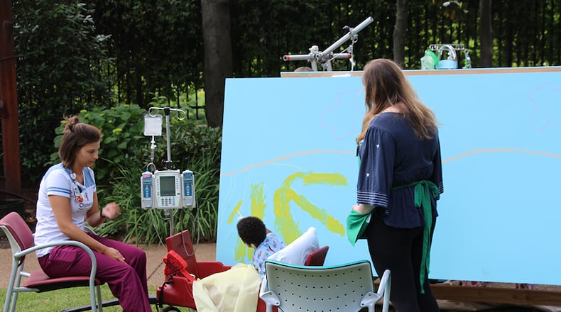 A Children's Healthcare of Atlanta at Egleston patient works on part of the new mural.