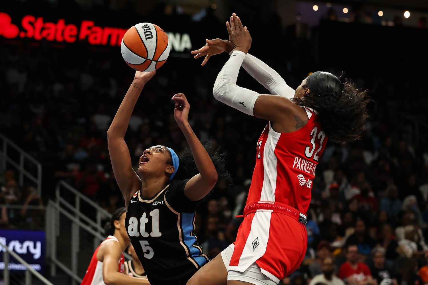Dream forward Angel Reese (left) shoots against Aces forward Cheyenne Parker-Tyus during the first half Sunday, May 17, 2026, at State Farm Arena in Atlanta. (Colin Hubbard for the AJC) 