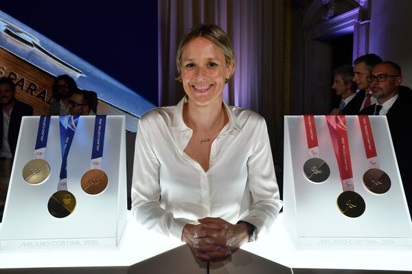 Former Italian swimmer Federica Pellegrini poses for photographers next to Milano Cortina 2026 Winter Olympics and Paralympics medals during the unveiling ceremony in Venice, Italy, Tuesday, July 15, 2025. (AP Photo/Luigi Costantini)