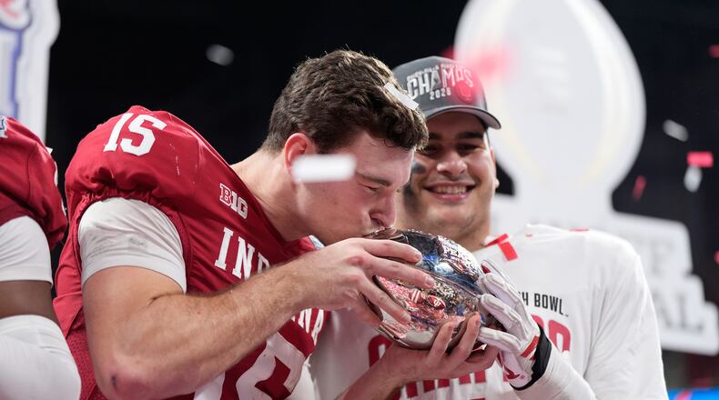 Indiana quarterback Fernando Mendoza (15) kisses the trophy after the Peach Bowl NCAA college football playoff semifinal against Oregon, Friday, Jan. 9, 2026, in Atlanta. (AP Photo/Brynn Anderson)