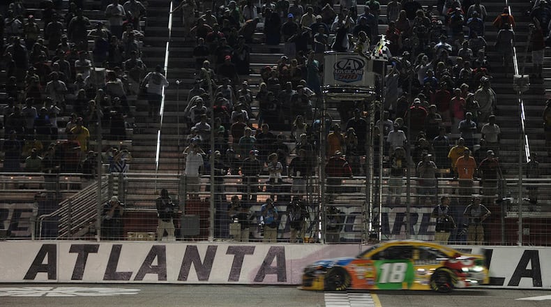 Kyle Busch crosses the finish line to win the Advocare 500 at Atlanta Motor Speedway on Sunday, September 1, 2013. JOHNNY CRAWFORD / AJC file