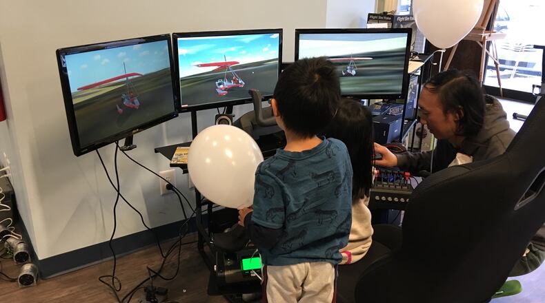 Children work on a flight simulator during an open house at the 21st Century STEM Academy. (HANDOUT PHOTO)