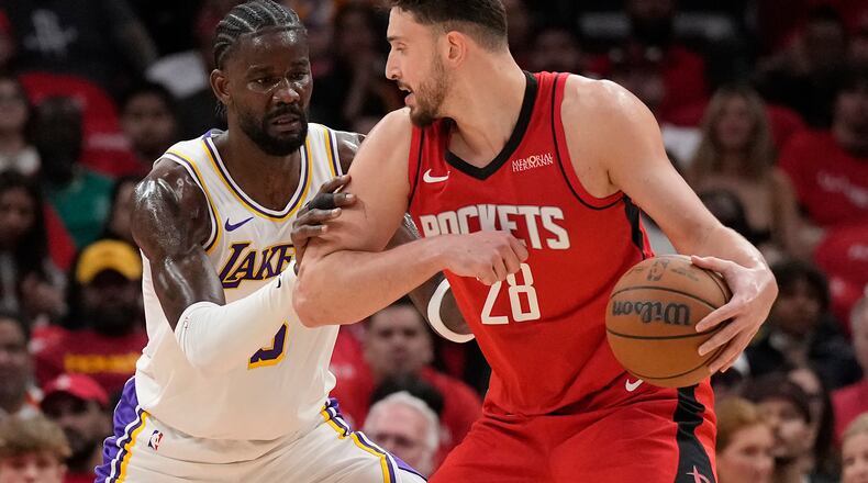 Houston Rockets center Alperen Sengun (28) controls the ball against Los Angeles Lakers center Deandre Ayton (5) during the first half in Game 4 of a first-round NBA basketball playoffs series, Sunday, April 26, 2026, in Houston. (AP Photo/Karen Warren)