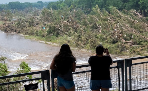 Onlookers review the damage along the Guadalupe River caused by recent flooding, Sunday, July 6, 2025, in Kerrville, Texas. (AP Photo/Rodolfo Gonzalez)