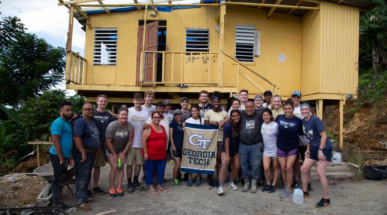 Georgia Tech athletes pose in front of a home in Vega Alta, Puerto Rico, as part of their service trip in May 2018. The team cut out the foundation from under the home, which was to be torn down, and poured in a new one. (Brad Malone/Georgia Tech Athletics)