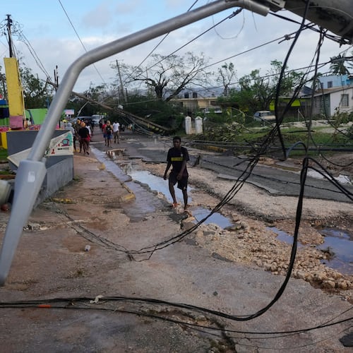 Residents walk through Santa Cruz, Jamaica, Wednesday, Oct. 29, 2025, after Hurricane Melissa passed. (AP Photo/Matias Delacroix)