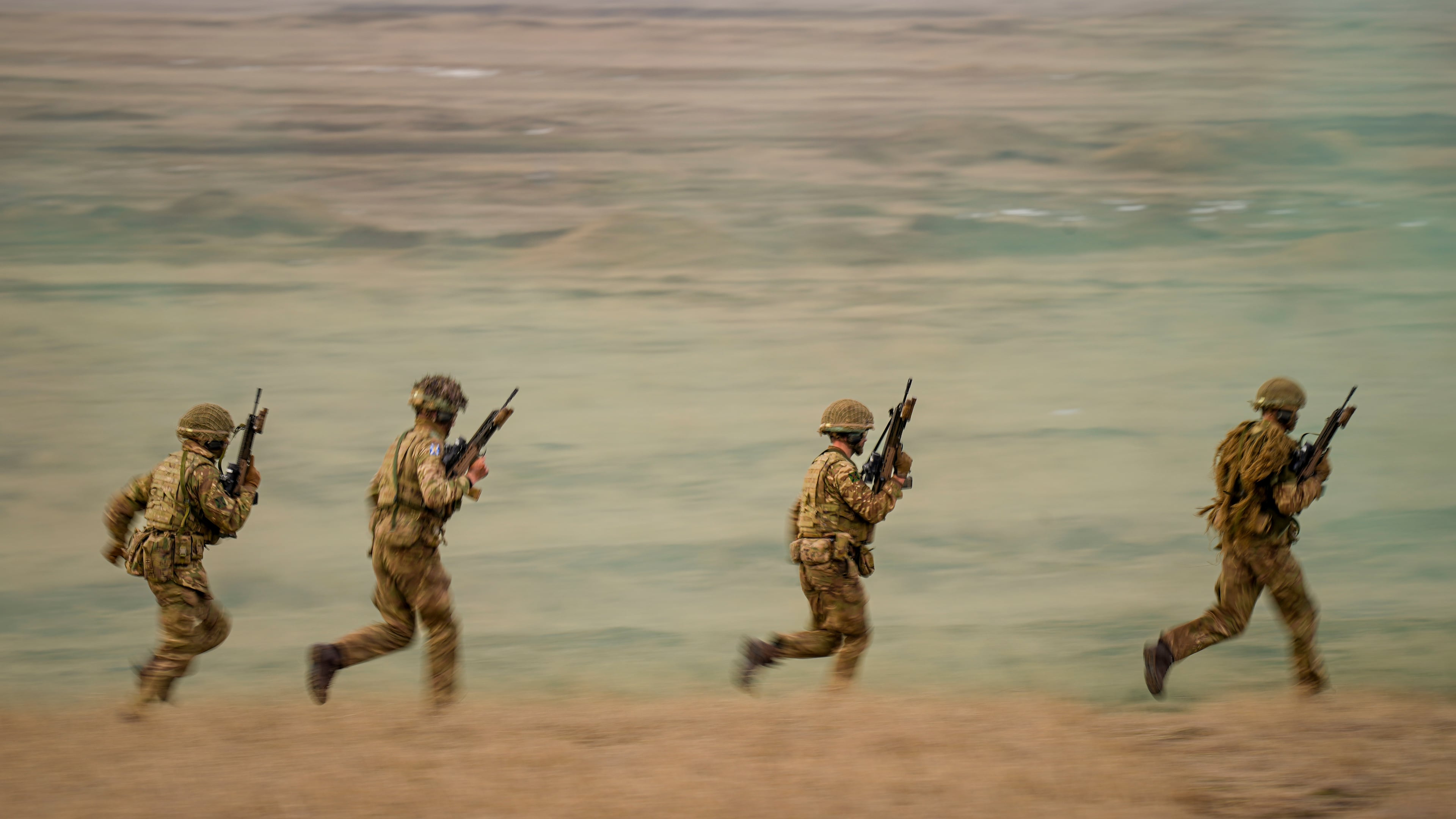 FILE- Servicemen run during the Steadfast Dart 2025 exercise, involving some 10,000 troops in three different countries from nine nations, representing the largest NATO operation planned this year, at a training range in Smardan, eastern Romania, Wednesday, Feb. 19, 2025. (AP Photo/Vadim Ghirda, file)
