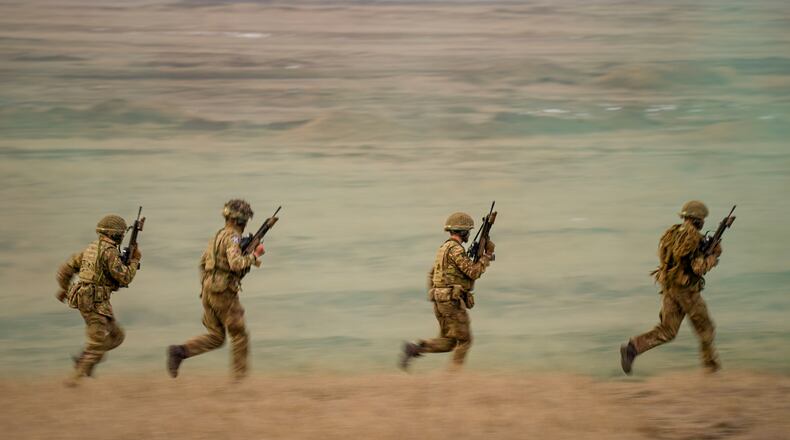 FILE- Servicemen run during the Steadfast Dart 2025 exercise, involving some 10,000 troops in three different countries from nine nations, representing the largest NATO operation planned this year, at a training range in Smardan, eastern Romania, Wednesday, Feb. 19, 2025. (AP Photo/Vadim Ghirda, file)