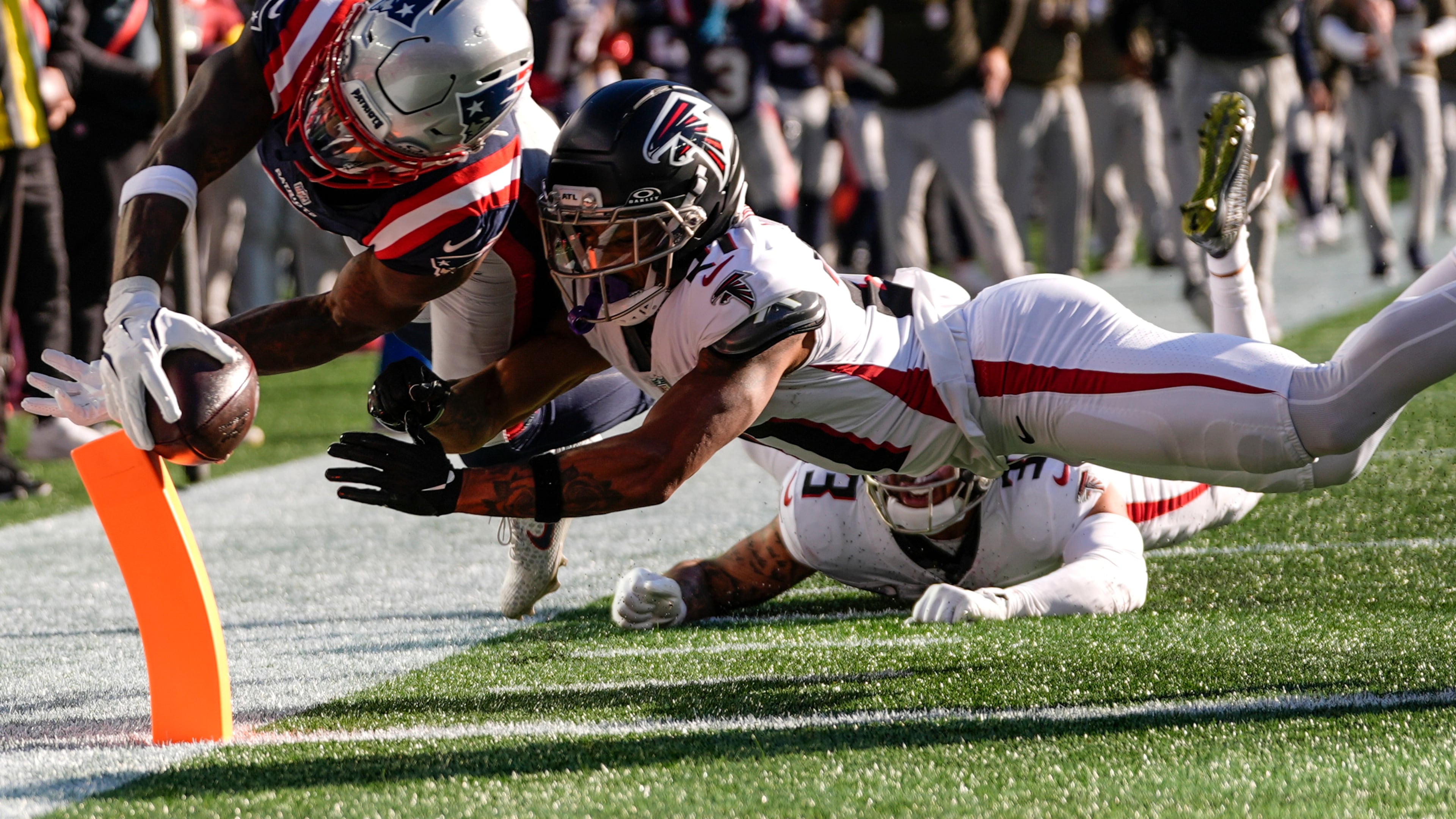 New England Patriots wide receiver Stefon Diggs (8) scores a touchdown against Atlanta Falcons cornerback Mike Hughes (21) during the first half of an NFL football game, Sunday, Nov. 2, 2025, in Foxborough, Mass. (AP Photo/Charles Krupa)