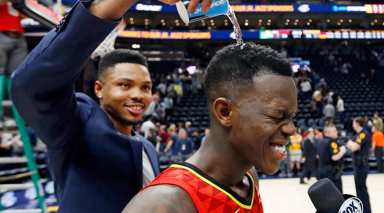 Atlanta Hawks guard Kent Bazemore, left, pours water over the head of Atlanta Hawks guard Dennis Schroder, right, while celebrating after their NBA basketball game against the Utah Jazz Tuesday, March 20, 2018, in Salt Lake City. (AP Photo/Rick Bowmer)