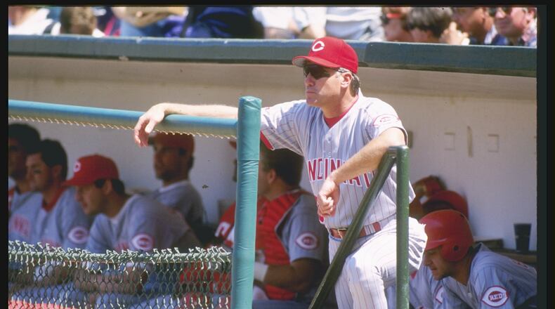 Former Reds manager Ray Knight, seen here looking on from the dugout in Wrigley Field during a 1996 game against the Cubs, was playing third base for the Reds in 1981 when a fan nearly fell over a railing in old Riverfront Stadium. He said, "I remember it clearly  . . . I saw him hanging up there, but I never knew how he actually grabbed the dang rail, the way it’s built.”