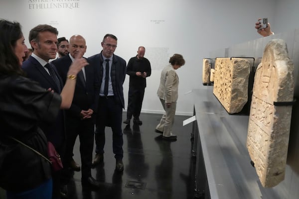 French President Emmanuel Macron, second left, listens to explanations as he visits the exhibition "Treasures rescued from Gaza" Monday, April 14, 2025 at the Arab World Institute (IMA) in Paris. (AP Photo/Michel Euler, Pool)