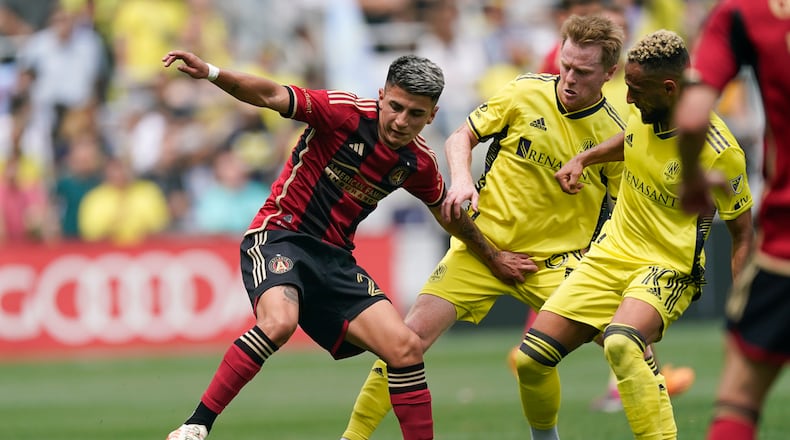Atlanta United midfielder Thiago Almada, left, moves the ball past Nashville SC midfielder Dax McCarty, center, and midfielder Hany Mukhtar (10) during the second half of an MLS soccer match Saturday, April 29, 2023, in Nashville, Tenn. (AP Photo/George Walker IV)