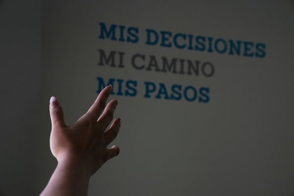 A health worker gestures towards a message that reads in Spanish; "My decisions, my road, my steps" during a tour of the MSI Foundation, an organization that offers information and help to women seeking abortions, in Mexico City, Thursday, May 8, 2025. (AP Photo/Marco Ugarte)