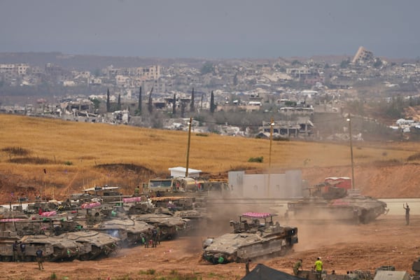 Israeli soldiers work on tanks and APCs at a staging area near the border with the Gaza Strip, in southern Israel, Thursday, May 15, 2025. (AP Photo/Ariel Schalit)