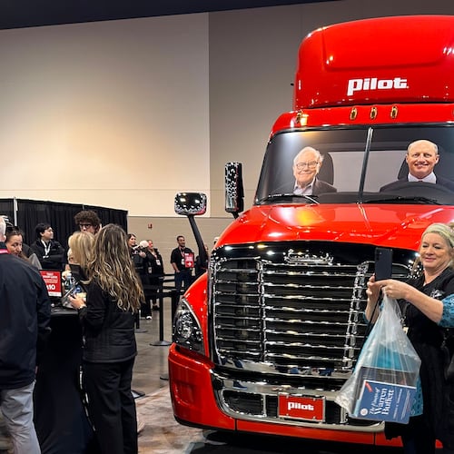 A Berkshire Hathaway shareholder takes a selfie in front of a Pilot truck stops semi truck with pictures of Berkshire's top two executives behind the wheel: new CEO Greg Abel and Chairman Warren Buffett on Friday, May 1, 2026 in Omaha, Neb. (AP Photo/Josh Funk)