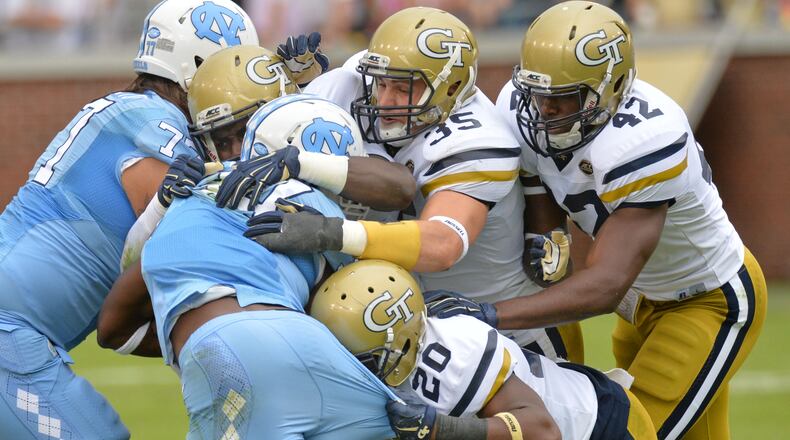 North Carolina Tar Heels running back Elijah Hood (34) is brought down by Georgia Tech Yellow Jackets linebacker Tyler Marcordes (35) and Georgia Tech Yellow Jackets defensive back Lawrence Austin (20) in the first half at Bobby Dodd Stadium on Saturday, October 3, 2015. HYOSUB SHIN / HSHIN@AJC.COM