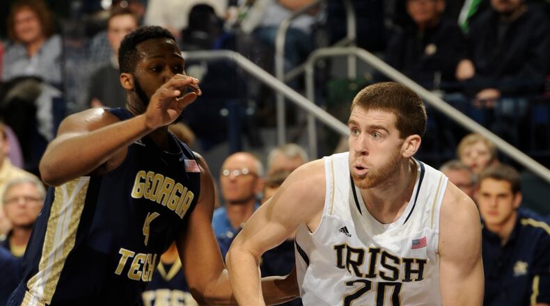 Notre Dame guard Austin Burgett, right, drives the lane as Georgia Tech forward Robert Carter Jr. defends in an NCAA college basketball game Wednesday, Feb. 26, 2014 in South Bend, Ind. (AP Photo/Joe Raymond)