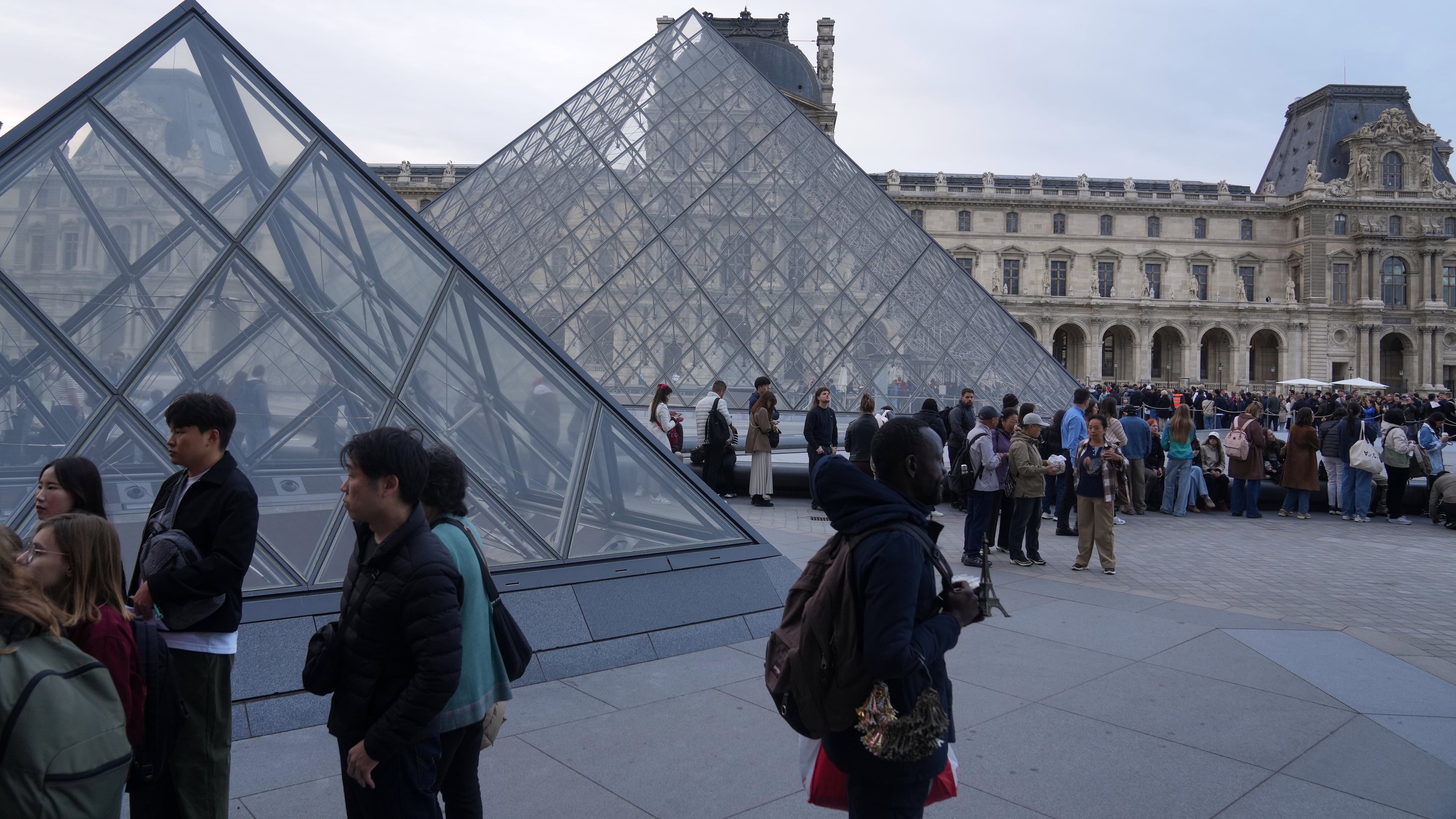 Visitors queue to enter the Louvre museum three days after historic jewels were stolen in a daring daylight heist, Wednesday, Oct. 22, 2025 in Paris. (AP Photo/Thibault Camus)