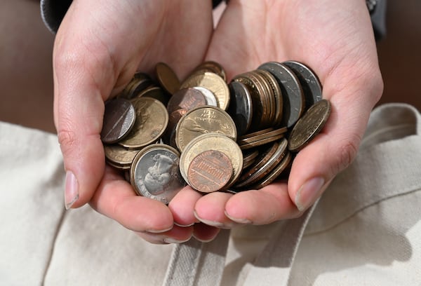 Dream Hain holds coins collected by her father and grandfather that she was able to salvage from her old dorm room. Hain was one of 143 students who lost precious possessions and were forced to move after the April 27 fire. (Hyosub Shin/AJC)