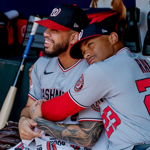 Washington Nationals first baseman Luis García Jr., left, is hugged in the dugout by first base coach Corey Ray (23) after he was scratched from the starting lineup before a baseball game against the Atlanta Braves, Sunday, Aug. 2, 2026, in Atlanta. (AP Photo/Erik S. Lesser)