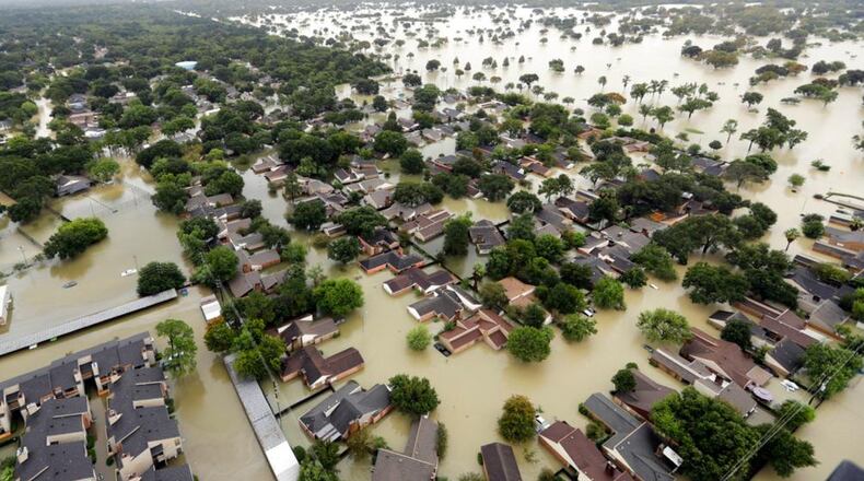 FILE - In this Tuesday, Aug. 29, 2017 file photo, water from Addicks Reservoir flows into neighborhoods as floodwaters from Tropical Storm Harvey rise in Houston. The chances of a hurricane drenching Texas, like Harvey did, have soared six fold in just a quarter century with global warming and will likely triple once again before the end of the century, says a new study published Monday, Nov. 12, 2017, in the Proceedings of the National Academy of Sciences. (AP Photo/David J. Phillip, File)