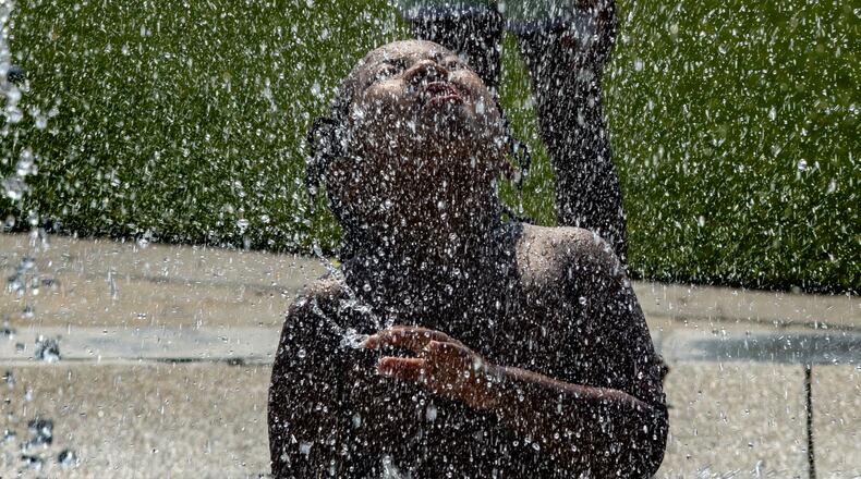 Devonte Tucker Jr.-6, a kindergartener with Wesley International Academy enjoyed the spray of cool water at the splash pad at Rodney Cook Sr. Park in Historic Vine City. (John Spink/AJC File Photo)