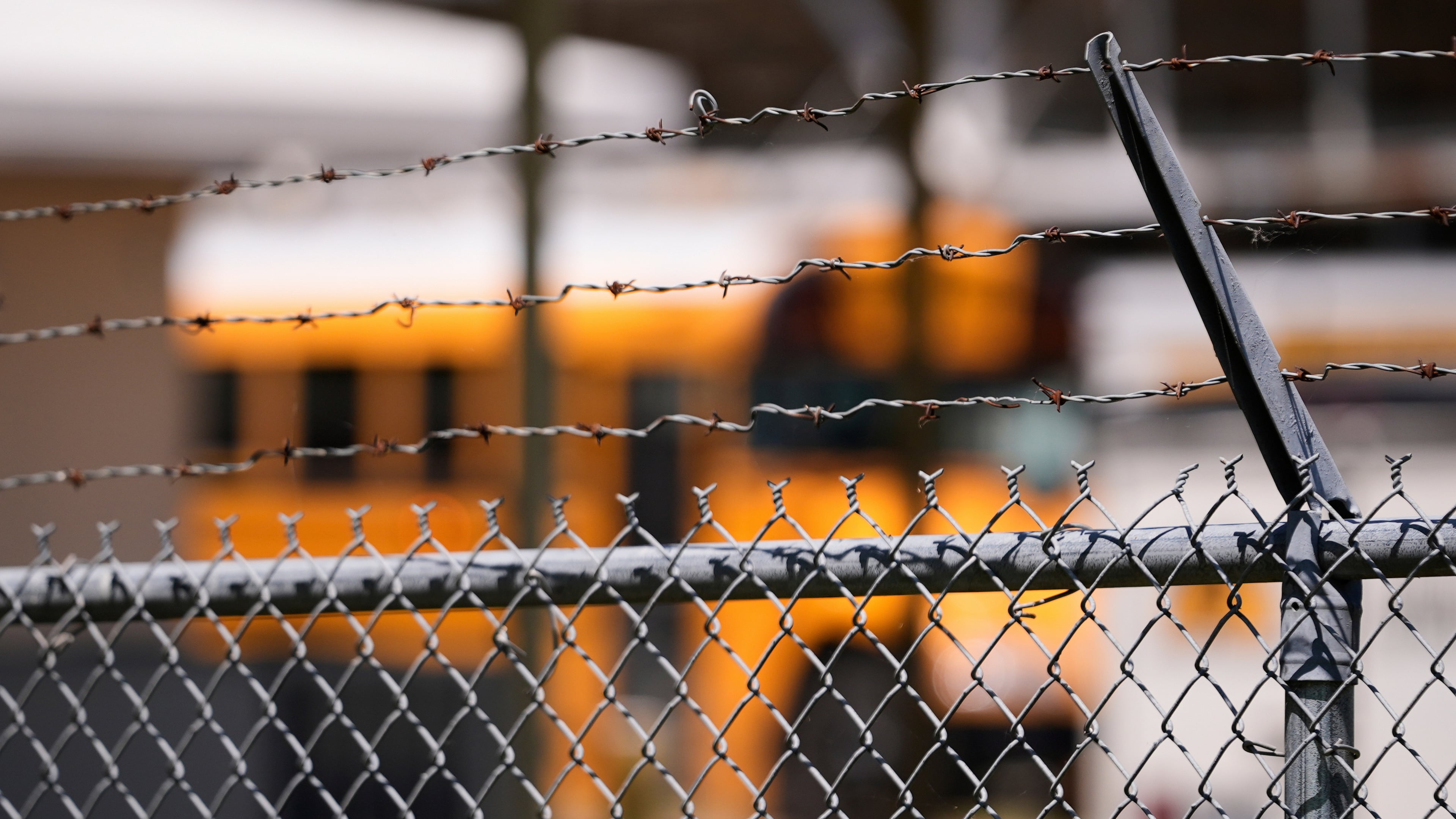 FILE - A school bus is seen behind a fence with barbed wire outside Ferriday High School in Ferriday, La., May 22, 2025. (AP Photo/Gerald Herbert, File)