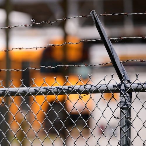FILE - A school bus is seen behind a fence with barbed wire outside Ferriday High School in Ferriday, La., May 22, 2025. (AP Photo/Gerald Herbert, File)