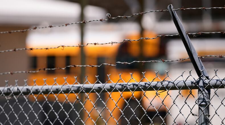 FILE - A school bus is seen behind a fence with barbed wire outside Ferriday High School in Ferriday, La., May 22, 2025. (AP Photo/Gerald Herbert, File)