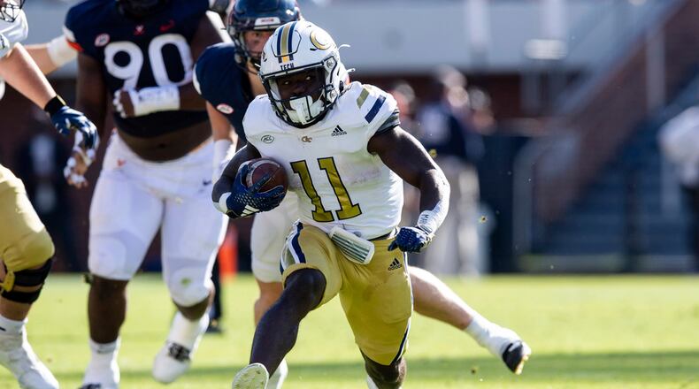 Georgia Tech running back Jamal Haynes (11) runs for a gain against the Virginia defense during the first half of an NCAA college football game Saturday, Nov. 4, 2023, in Charlottesville, Va. (AP Photo/Mike Caudill)