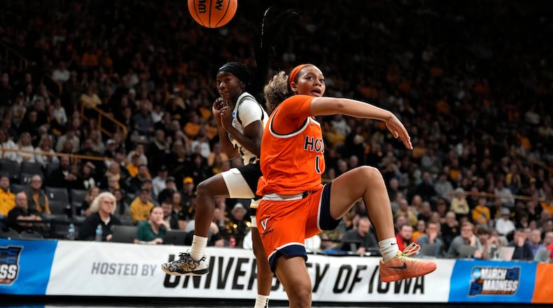 Virginia guard Paris Clark (1) fights for a loose ball with Iowa guard Chazadi Wright, left, during the first half in the second round of the NCAA college basketball tournament, Monday, March 23, 2026, in Iowa City, Iowa. (AP Photo/Charlie Neibergall)