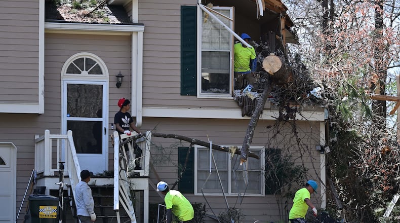 Workers, clean up damaged house near Paulding County High School after a storm passed through, Sunday, March 16, 2025, in Dallas. National Weather Service teams will be conducting a damage survey in the Paulding County/Dallas area, which sustained “pretty significant” damage from the storms, NWS Senior Meteorologist Dylan Lusk told The Atlanta Journal-Constitution on Sunday morning. (Hyosub Shin / AJC)