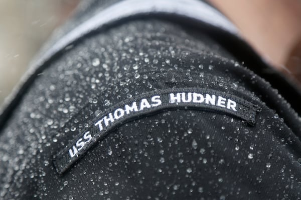 FILE - Water droplets from rain and melting snow gather on the shoulder of a crew member of the the future USS Thomas Hudner, a U.S. Navy destroyer named after Korean War veteran Thomas Hudner, during the ship's christening ceremony at Bath Iron Works in Bath, Maine, April 1, 2017. (AP Photo/Mary Schwalm, File)