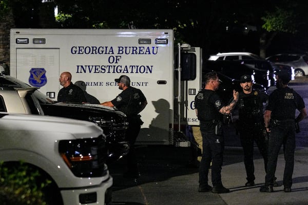 Numerous law enforcement officers, including from the GBI, were at the scene off Windy Hill Road late Tuesday. (Ben Hendren for the AJC)