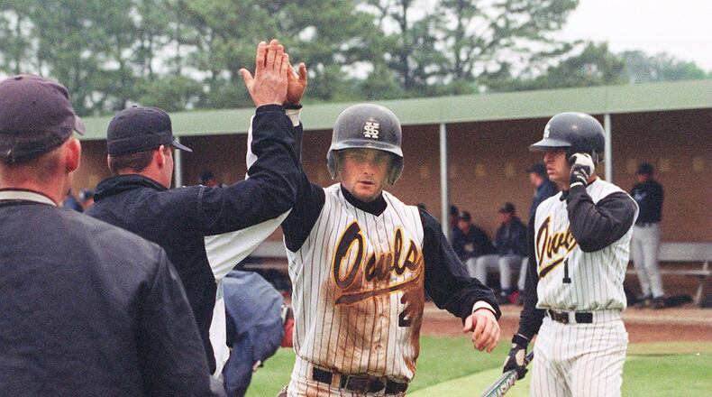 Kennesaw State University second baseman Kevin Baldwin (2) receives congratulations from teammates after scoring during a game against Augusta State. KSU pumped about $42 million of student fees into its athletic programs to keep them going between 2011 and 2014. (AJC Staff Photo/Bob Giles)