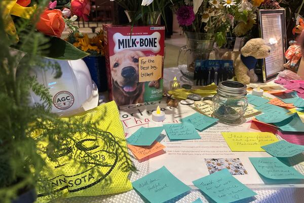Amid the flowers and other mementos left in honor of former Minnesota House Speaker Melissa Hortman outside the Minnesota House chamber at the state capitol in St. Paul, Minn., on Friday, June 27, 2025, was a box of dog biscuits in honor of her dog, Gilbert, who was seriously injured and had to be put down after Hortman and her husband, Mark, were fatally shot June 14. (AP Photo/Steve Karnowski)
