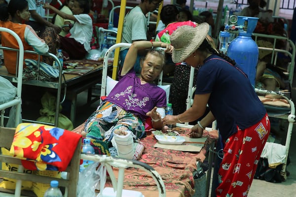 In this photo released by Xinhua News Agency, injured people receive treatment at a makeshift tent in the earthquake hit Sagaing, Myanmar, Tuesday, April 1, 2025. (Myo Kyaw Soe/Xinhua via AP)